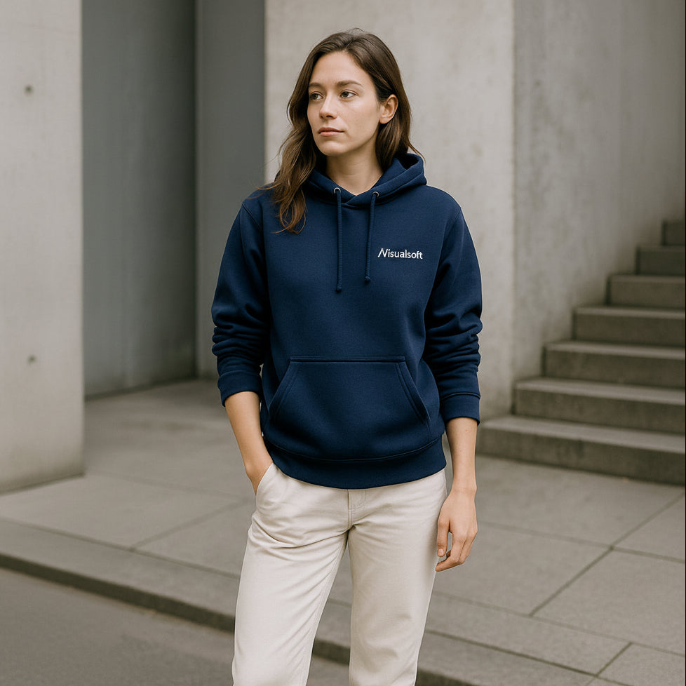 Woman wearing a navy blue Visualsoft hoodie and light-colored trousers, standing outdoors.