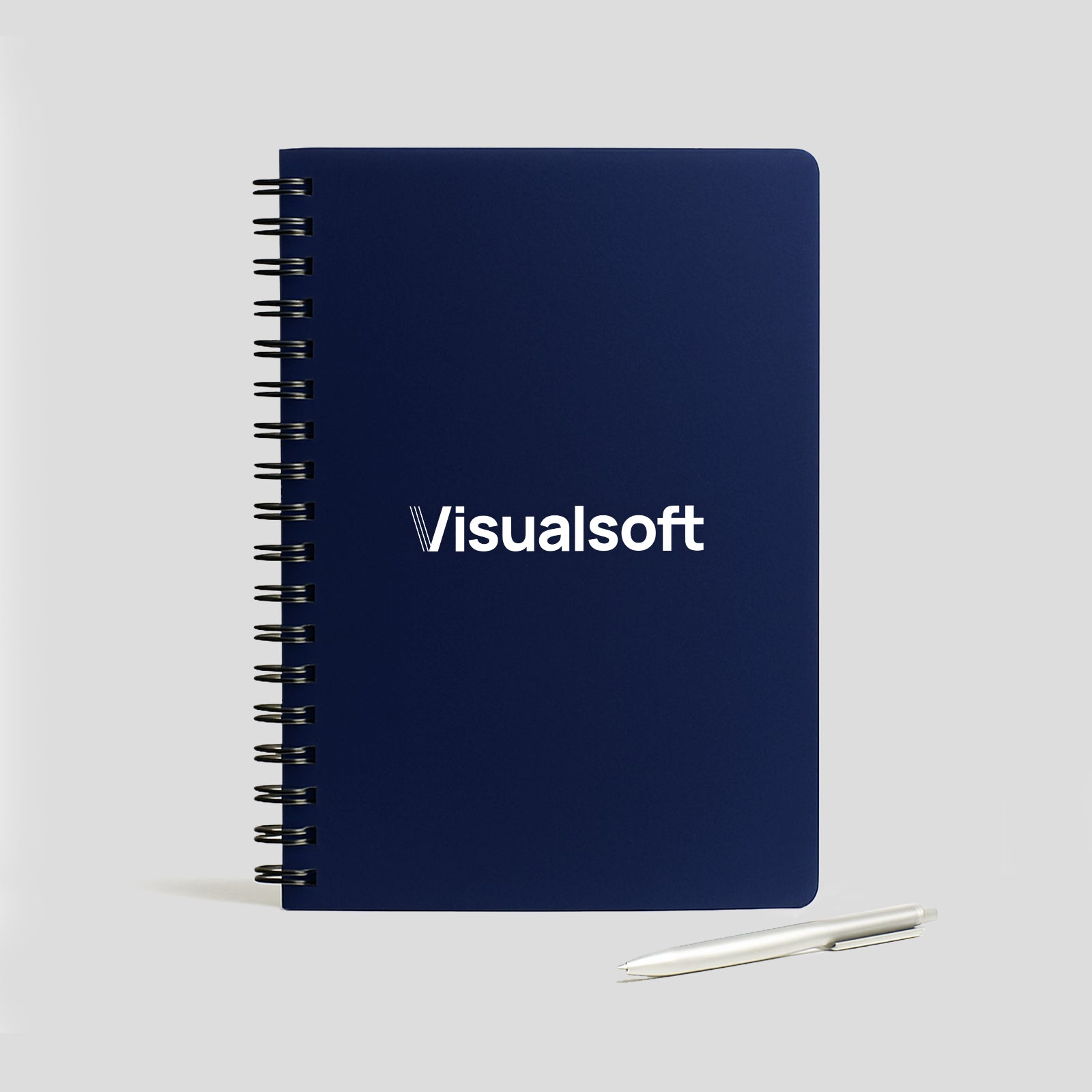 Dark blue spiral notebook with Visualsoft logo and a silver pen.