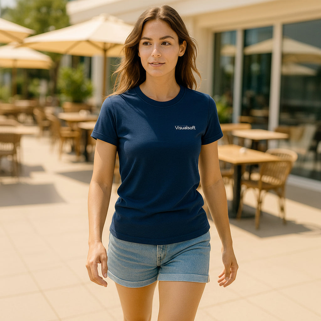 Woman wearing a navy blue t-shirt with the Visualsoft logo and denim shorts walking outdoors