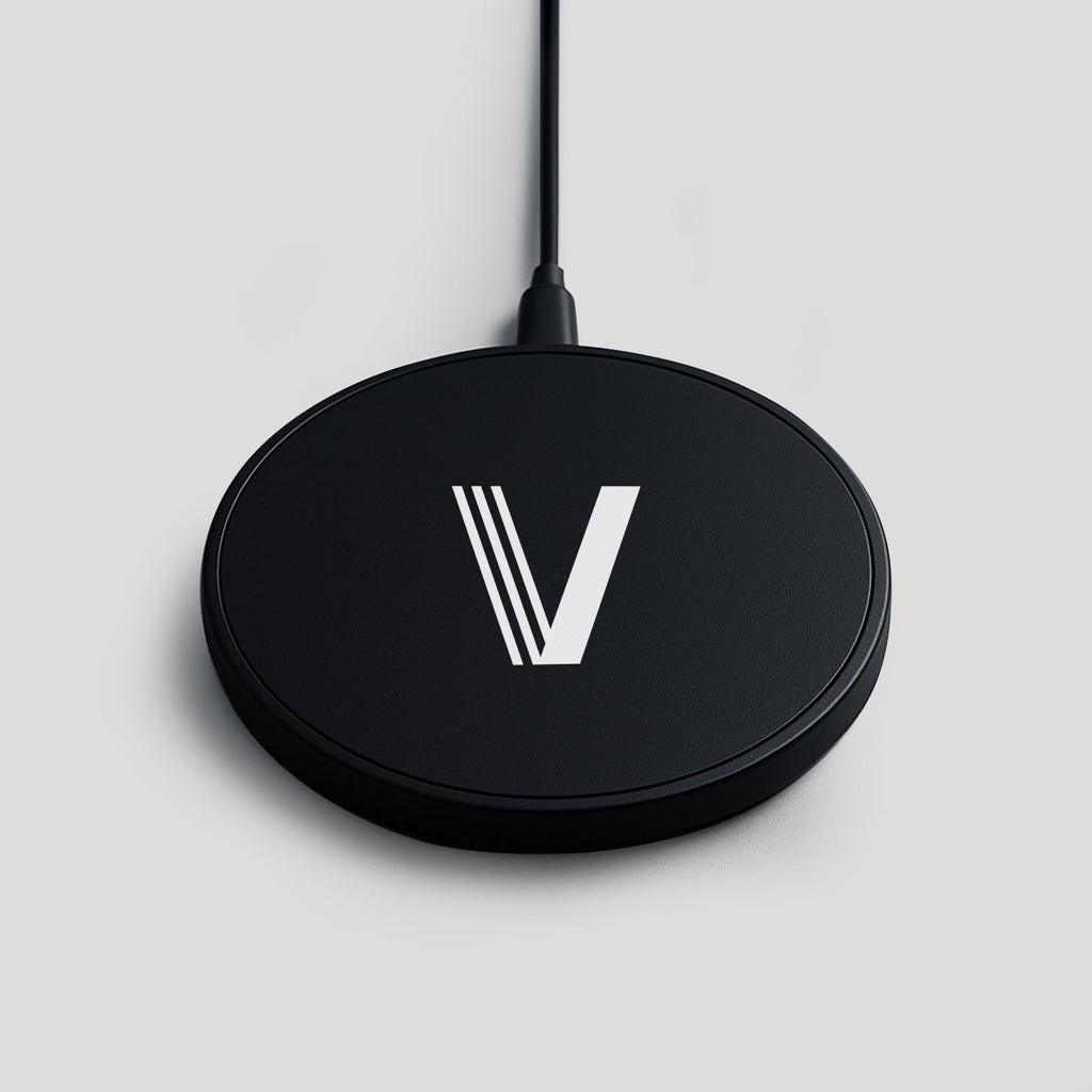 Black wireless charger with a white V logo on a light grey background.