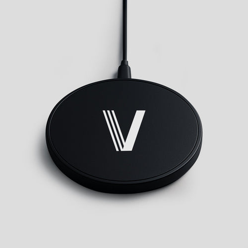 Black wireless charger with a white V logo on a light grey background.